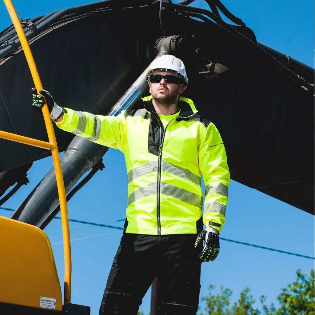 Man in hi-vis safety jacket hanging on side of digger